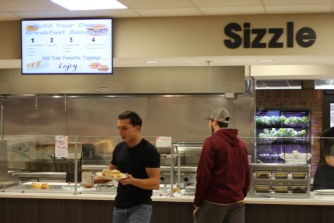 Students receive their breakfast sandwich from the cafes Sizzle station.