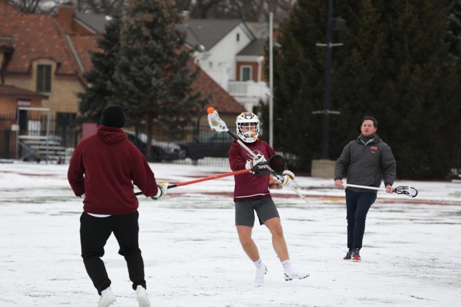Mens lacrosse player Justin Headley practices against head coach Scott Gwyn and Graduate Assistant Jacob Karmia in an early season practice 