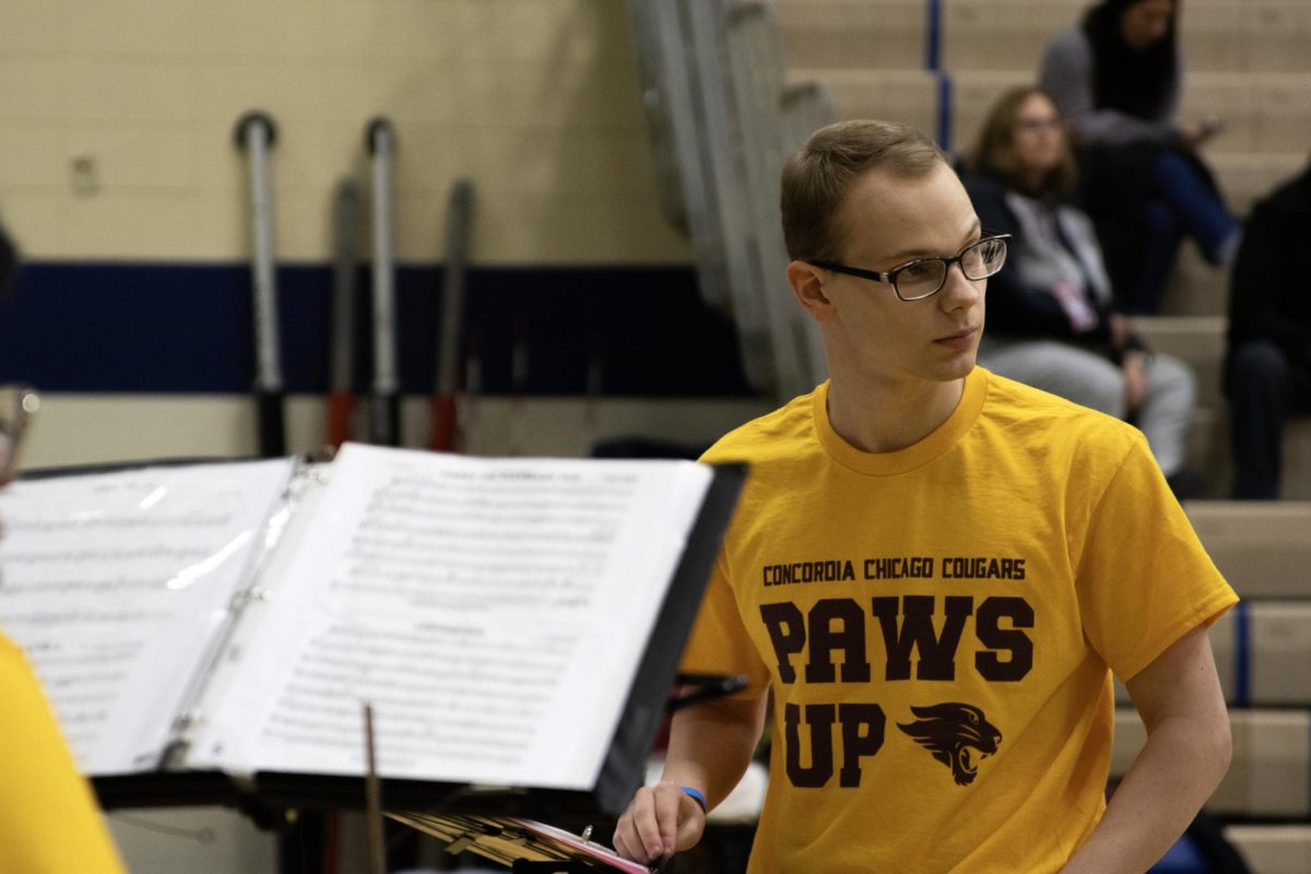 CUC Student Conductor, Owen Kaiser, awaiting the moment to conduct the Cougar Band at the penultimate CIT in the Concordia University Wisconsin Field House