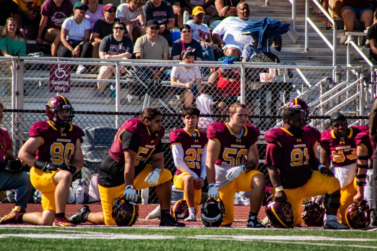 Football players kneel in respect to injured player during the Homecoming 2025 game October 4th