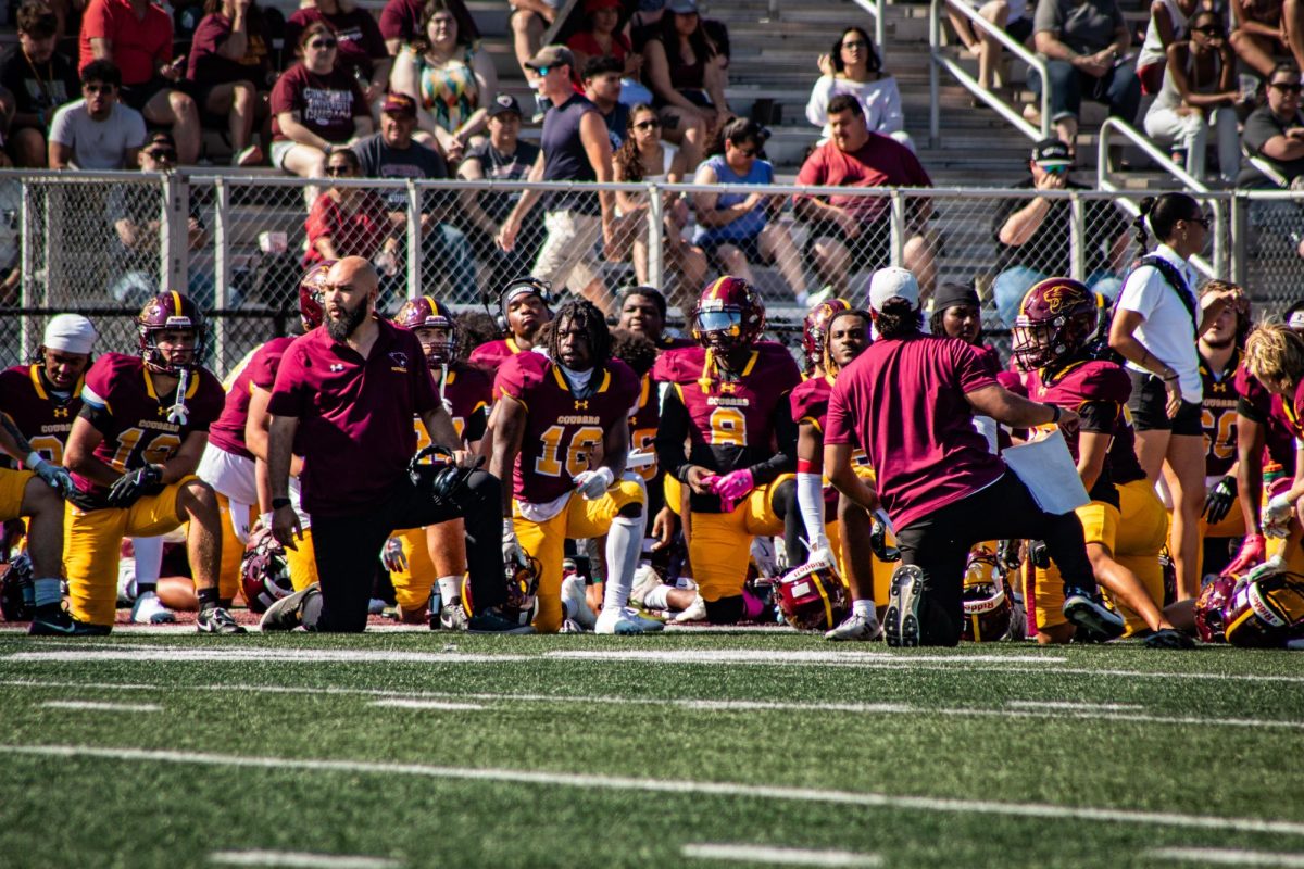 Football players and coaches kneel to respect injured player during the Homecoming 2025 game October 4th
