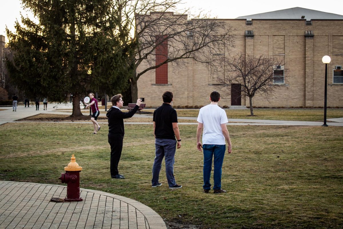 Students play frisbee in the Triangle and enjoy the warm weather on February 16th.
